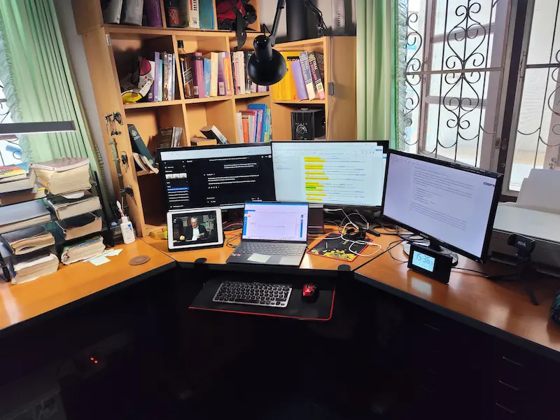 Funktionale Schreibtisch-Umgebung mit Laptop und drei Monitoren für die Wörterbuch-Entwicklung